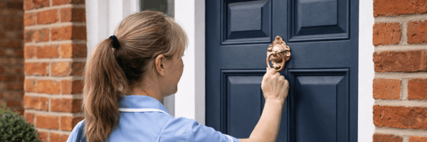 Professional care worker visiting client's home, representing domiciliary care services that use Vera for medication monitoring between visits